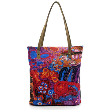 A tote bag printed with artwork by Andrea Adamson with brown straps.