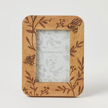 A wooden photo frame with an engraved design of bees and leaves.