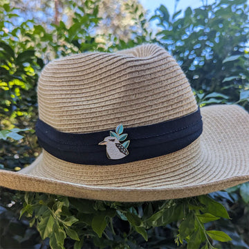 A kookaburra shaped enamel pin on a white background.