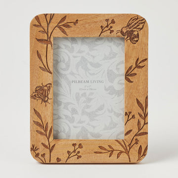 A wooden photo frame with an engraved design of bees and leaves.