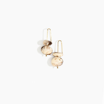 Pair of gold and beige resin earrings on a white background.