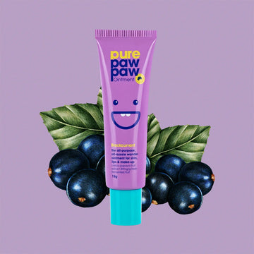 Purple tube of 'pure paw paw' ointment with black currants and leaves on a purple background