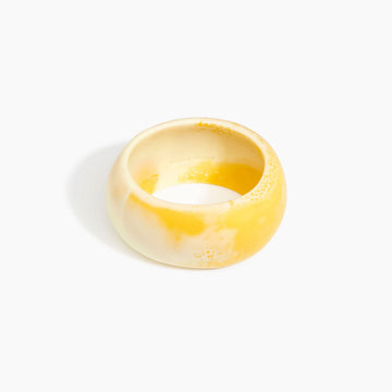 Yellow resin bangle on a white background.