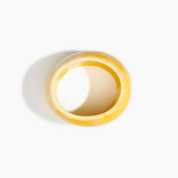 Yellow resin bangle on a white background.