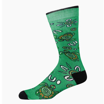 A green sock with a black heel and toe illustrated with turtles.