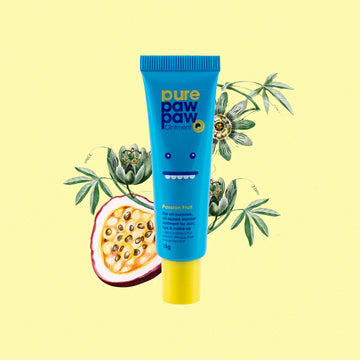 Blue tube of pure paw paw with a passion fruit and leaves on a yellow background.