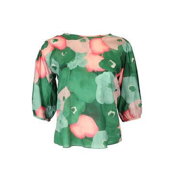 A women's blouse printed with a green and pink floral print.
