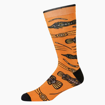 An orange sock with a black heel and toe and illustrated with fish.