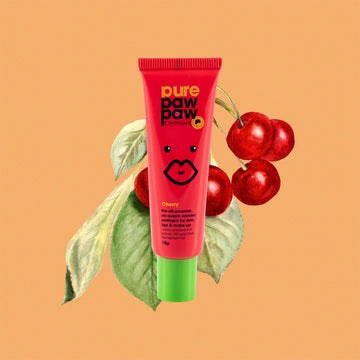 Pink tube of pure paw paw balm with cherries and leaves on a peach background.
