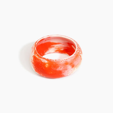 Orange and white bangle on a light gray background.
