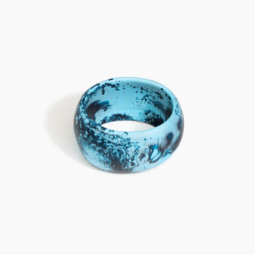 Blue and black marbled bangle on a white background.
