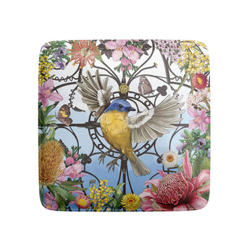 Decorative magnet with a bird and floral design on a white background.
