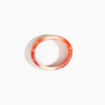 Bangle with red and white gradient on a white background.
