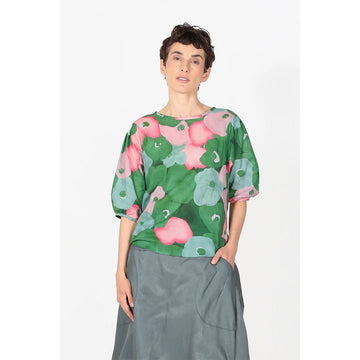 A women's blouse printed with a green and pink floral print.