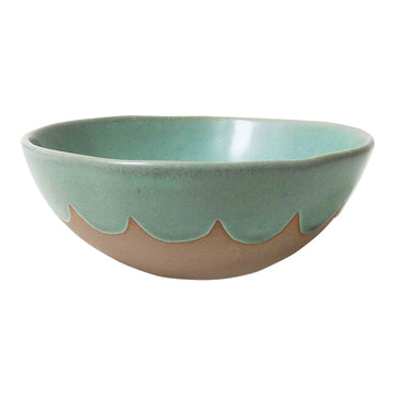 A stoneware bowl in brown covered with a blue green scallop pattern on the top.