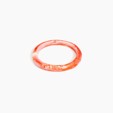 Red resin bangle on a white background.