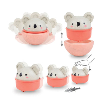 A round koala toy sitting in a pink cup.