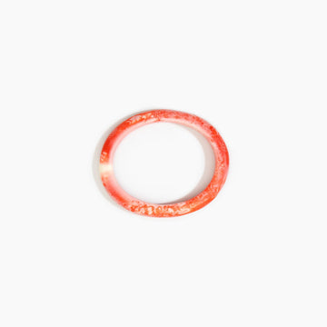 Red resin bangle on a white background.