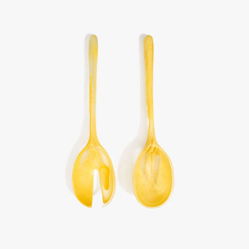Two yellow resin salad servers on a white background.