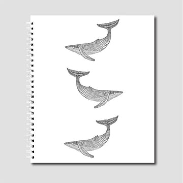 A spiral notebook illustrated with three black and white whales.