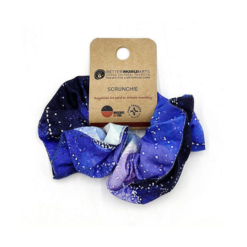 A scrunchie printed with blue and black artwork attached to a brown product label.