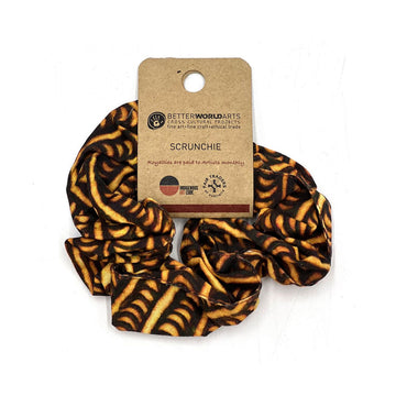 A scrunchie printed with artwork in yellow and brown attached to a brown label.
