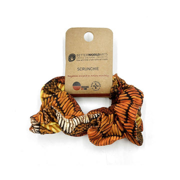 A scrunchie printed with artwork in shades of brown attached to a brown card label.