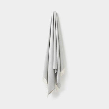 Gray throw with white border on a white background.