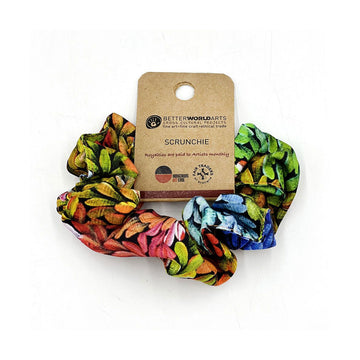 A scrunchie printed with colourful artwork attached to a brown card.