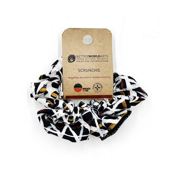 A scrunchie printed with artwork in black, white and brown attached to a brown card.