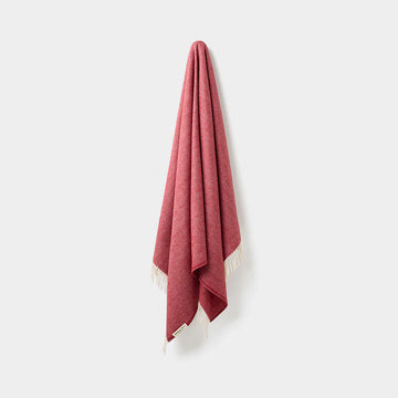 Red throw with white border on a light gray background.