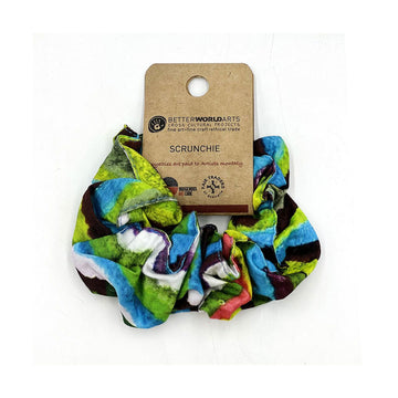 A scrunchie printed with blue and green artwork attached to a brown card.