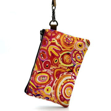 A zippered coin purse printed with artwork by Cedric Varcoe in shades of red and yellow.