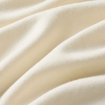 Cream-colored scarf with brand logo on a white background.