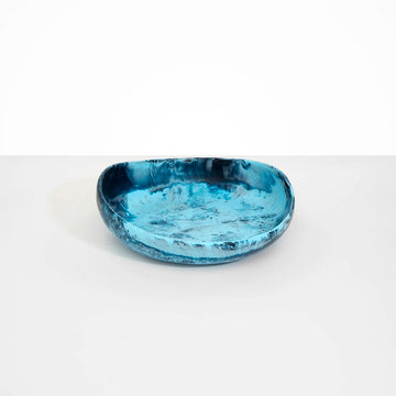 An irregular shaped round resin bowl in blue.