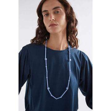 A light blue necklace made up of long and cube shaped beads.