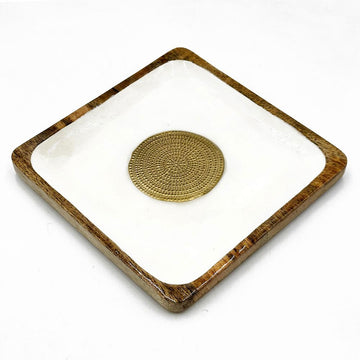 A wooden square tray painted white on the inside and a round gold medallion in the middle.