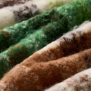 Plaid scarf with brown, green, and white colors on a white background.