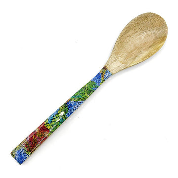 A wooden spoon printed with artwork by Patricia napurrula Multa on the handle.