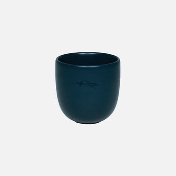 Dark blue ceramic cup on a light gray background