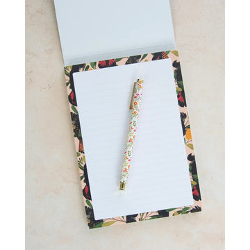 Writing pad with a design of black cockatoos and banksia flowers featuring the brand 'earth greetings'.