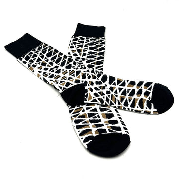 A pair of socks printed with artwork by Paulina Puruntatameri are overlapping each other.