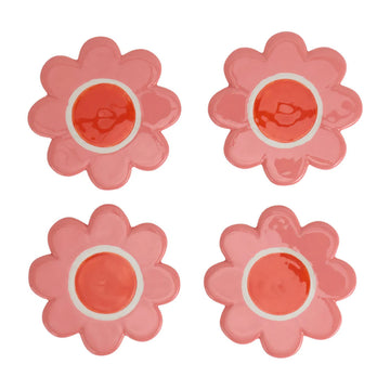 A set of four ceramic coasters shaped like flowers in pink.
