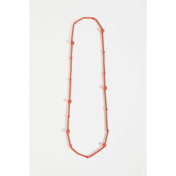 An orange necklace made up of long and cube shaped beads.