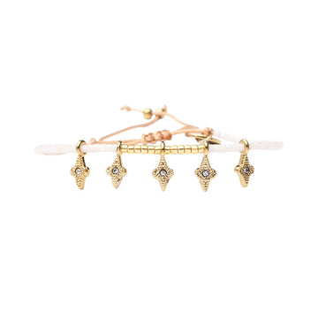 A white and gold beaded bracelet with star shaped gold charms.