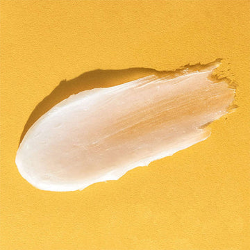 A small pot shaped like a honey pot in yellow and purple with the text 'Frudia Delivered from Fruit'.