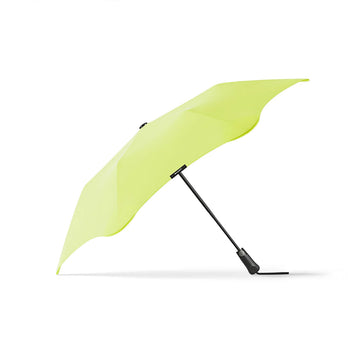 An open umbrella with a lime green top and black handle.