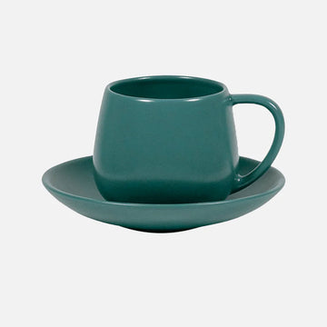 Teal mug and saucer set on a light gray background.