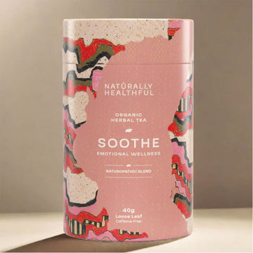 Pink cylindrical tea canister with abstract designs and text on a beige background.