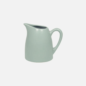 Light green ceramic pitcher on a white background.